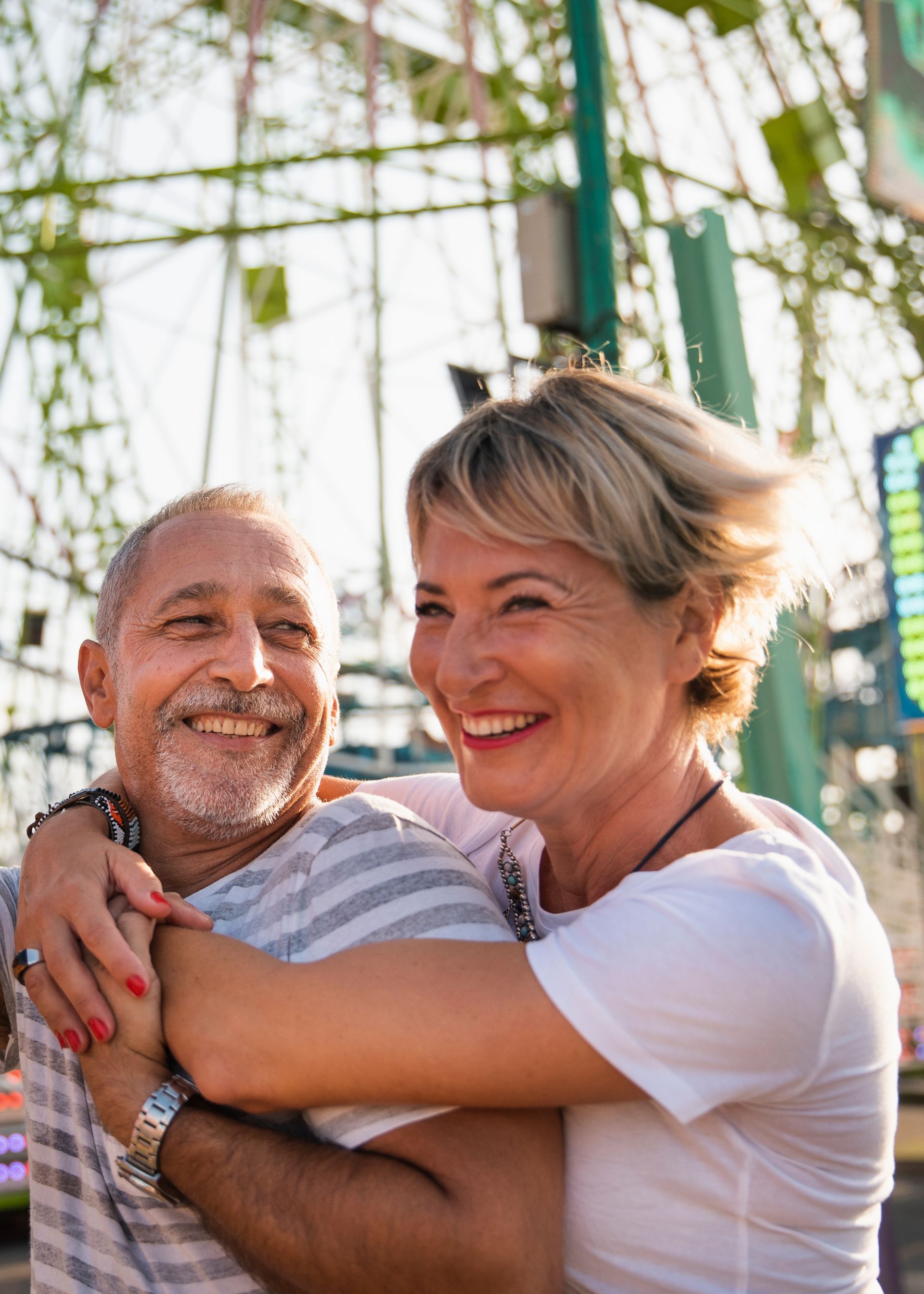 A man and a woman are hugging each other and looking at each other.