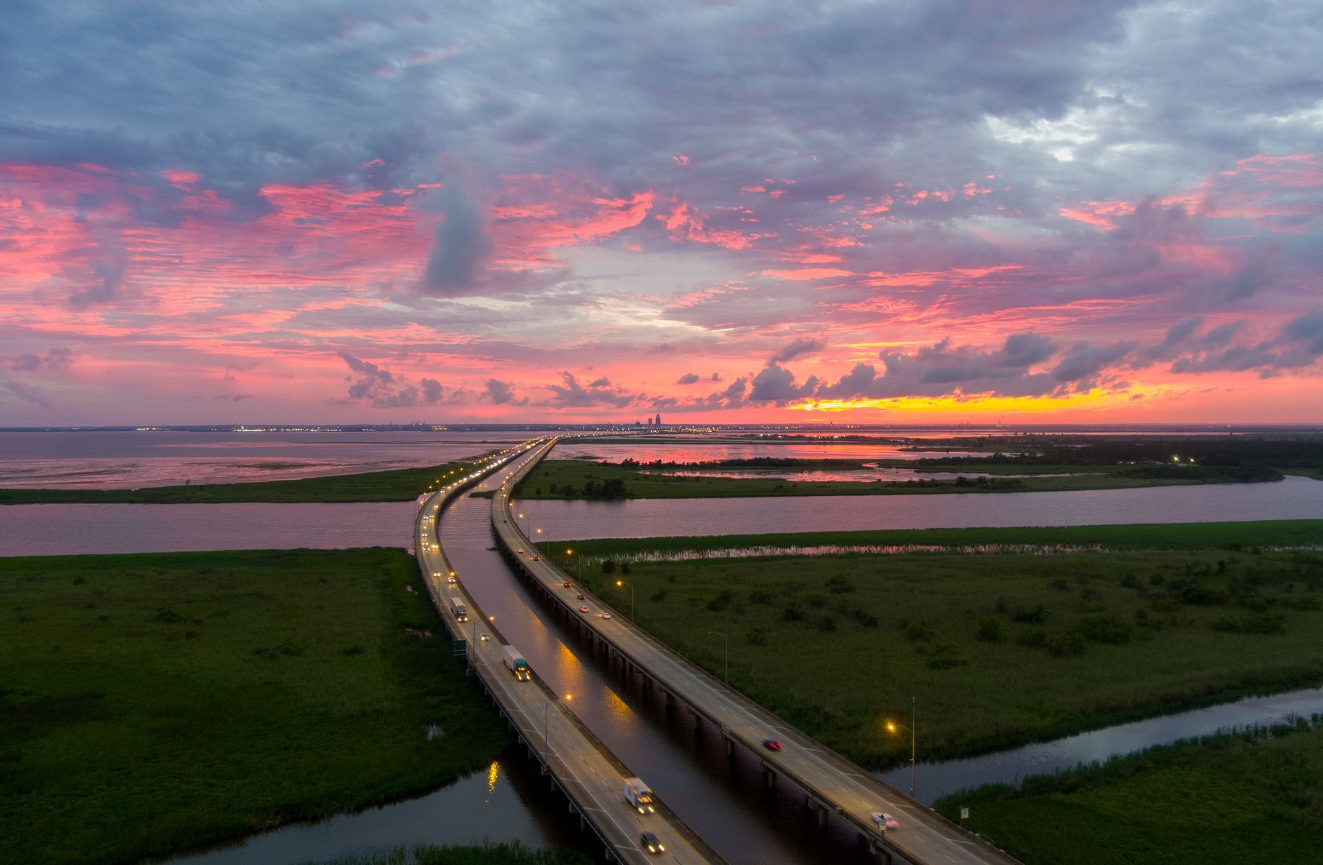 A sunset over a sandy beach with a cloudy sky