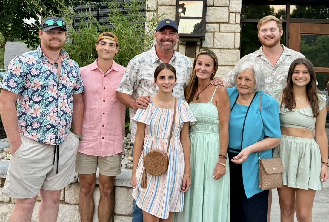 A practitioner in blue scrubs performs a neck adjustment on a person lying down.