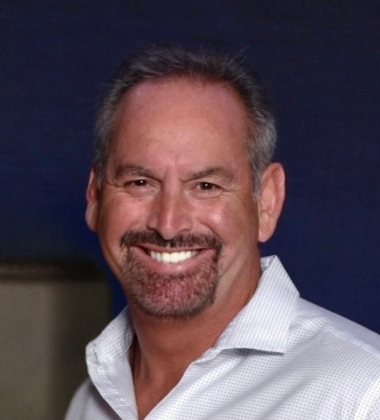 A massage therapist applies gentle pressure to a person’s lower back while they lie face down.