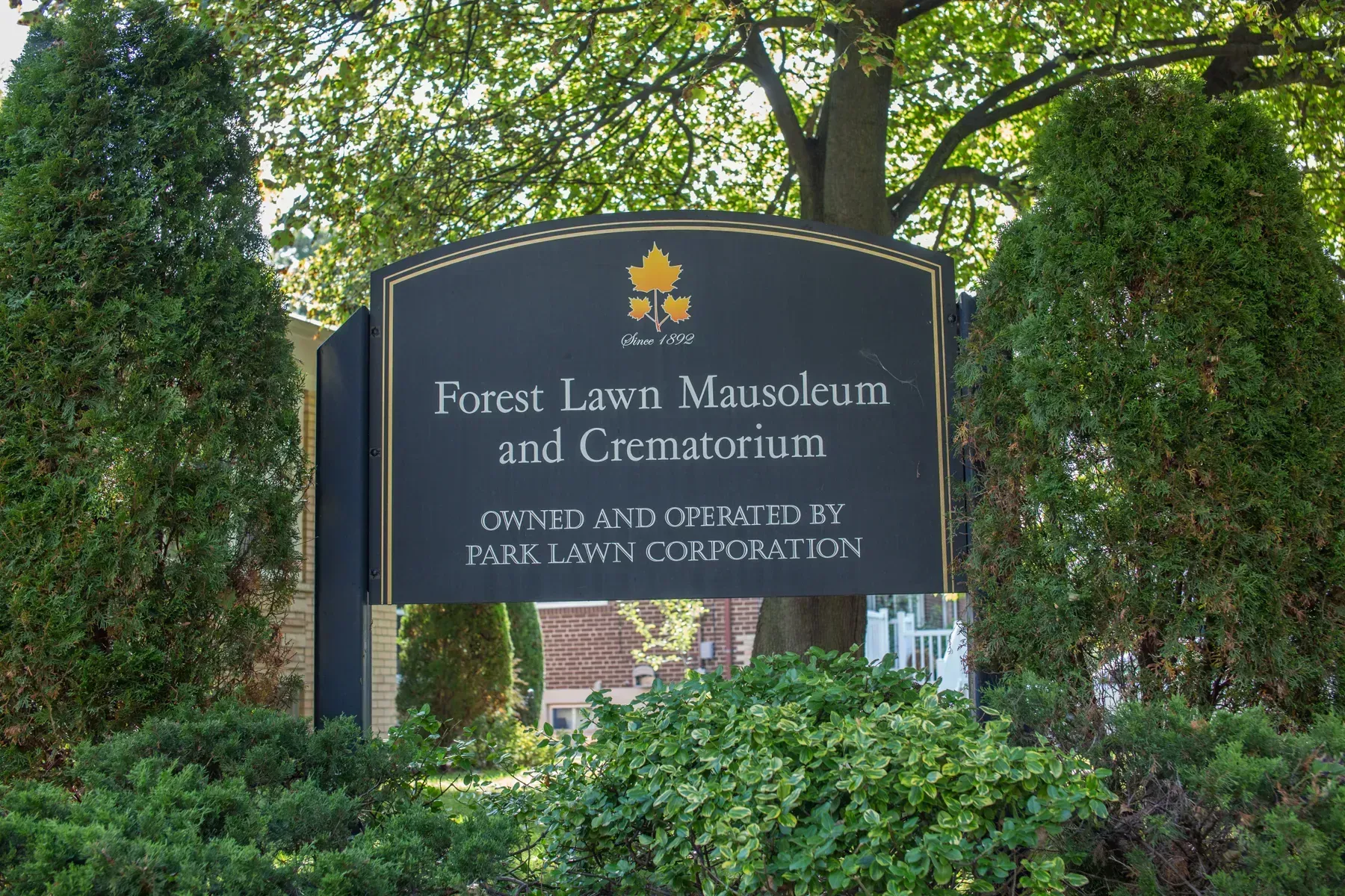 Forest Lawn Museum and Crematorium sign amid greenery and trees