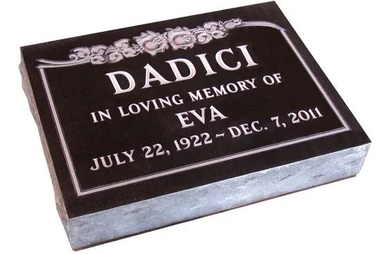 Black memorial plaque engraved with the name DADICI and dates for Eva, with floral decoration