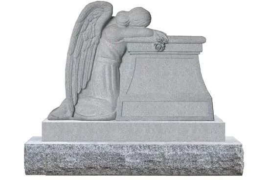 Gray stone angel resting on a tomb, with folded wings and head bowed in a cemetery memorial sculpture.