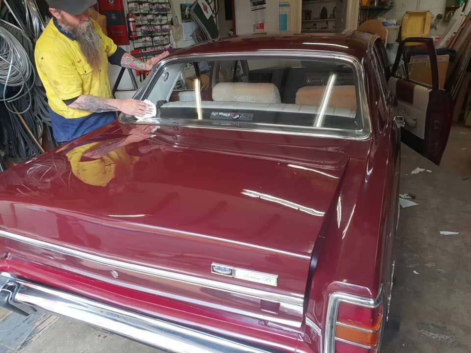 Two Men Are Working On A Black Sports Car In A Garage — Petrena Windscreens In Meringandan, QLD