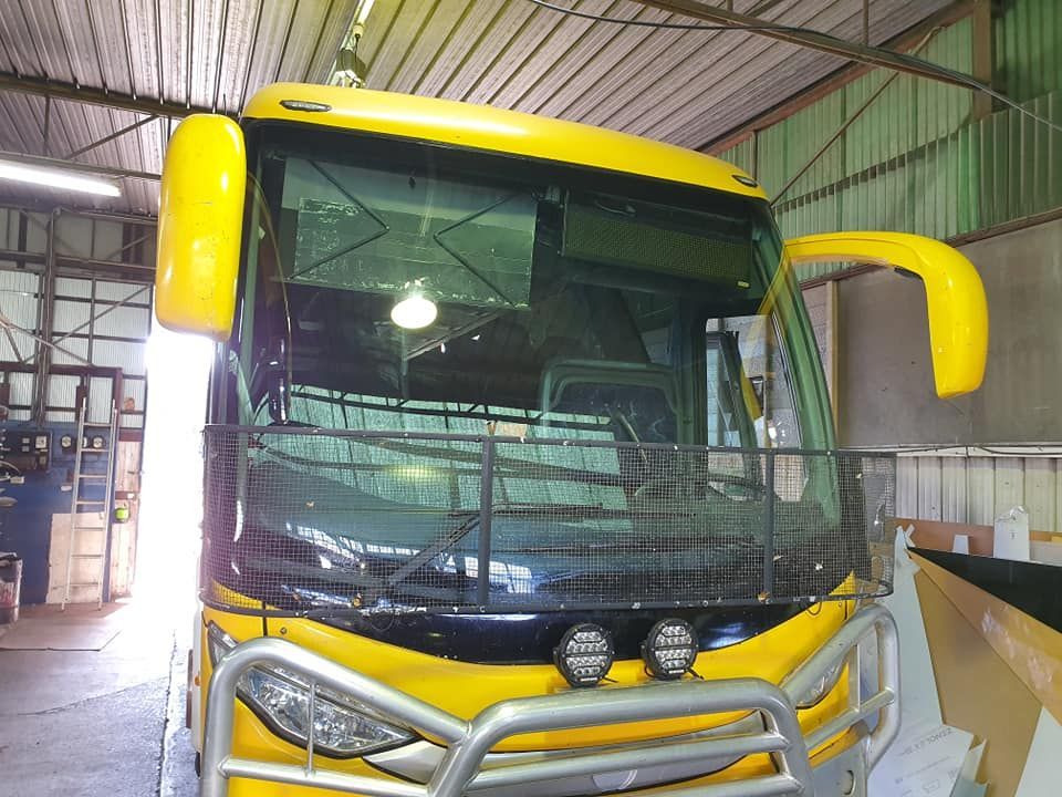 A Yellow Bus Is Parked Inside Of A Building — Petrena Windscreens In Toowoomba City, QLD