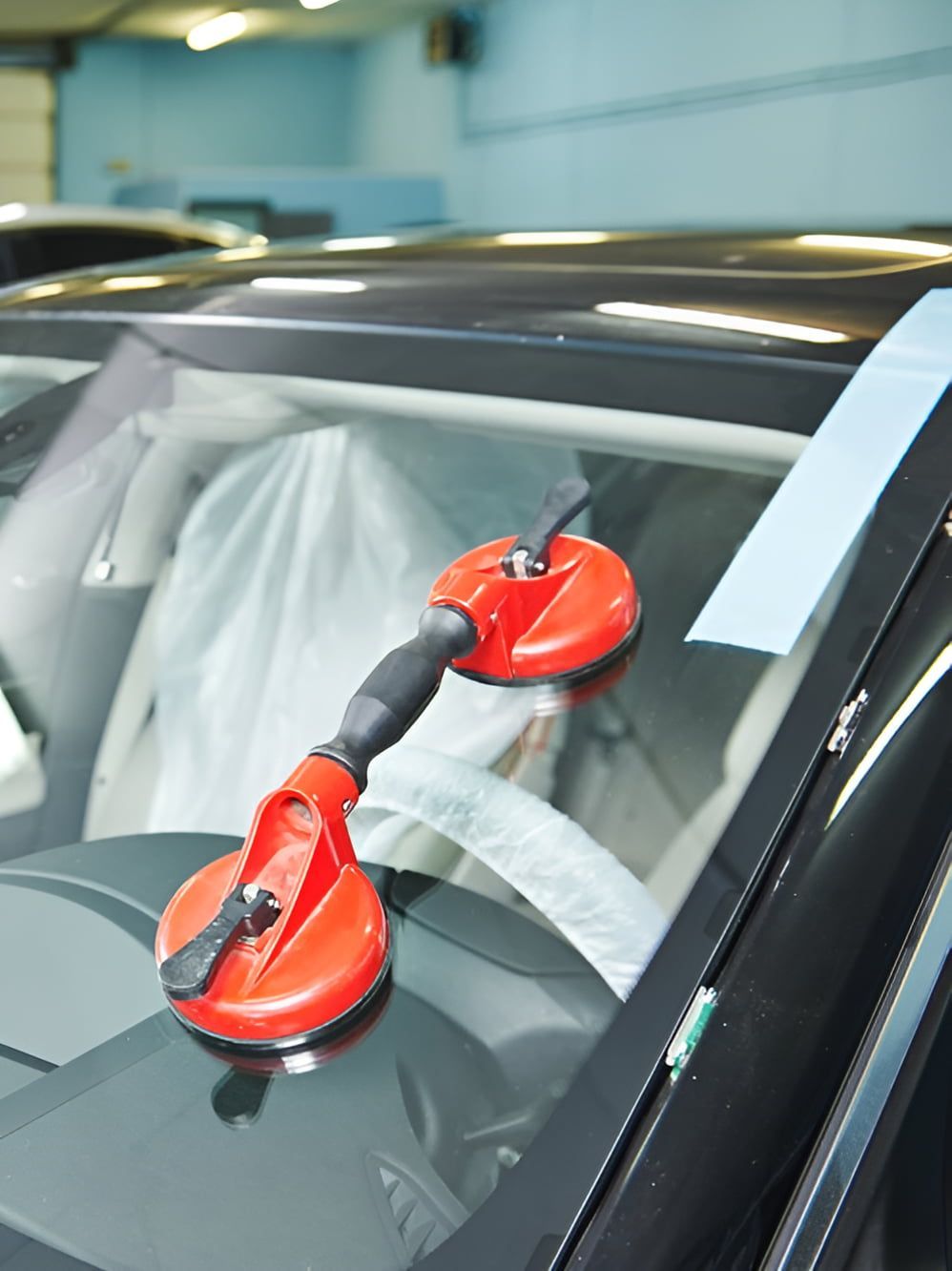 A Car Windshield Is Being Replaced With A Red Suction Cup — Petrena Windscreens In Clifton, QLD