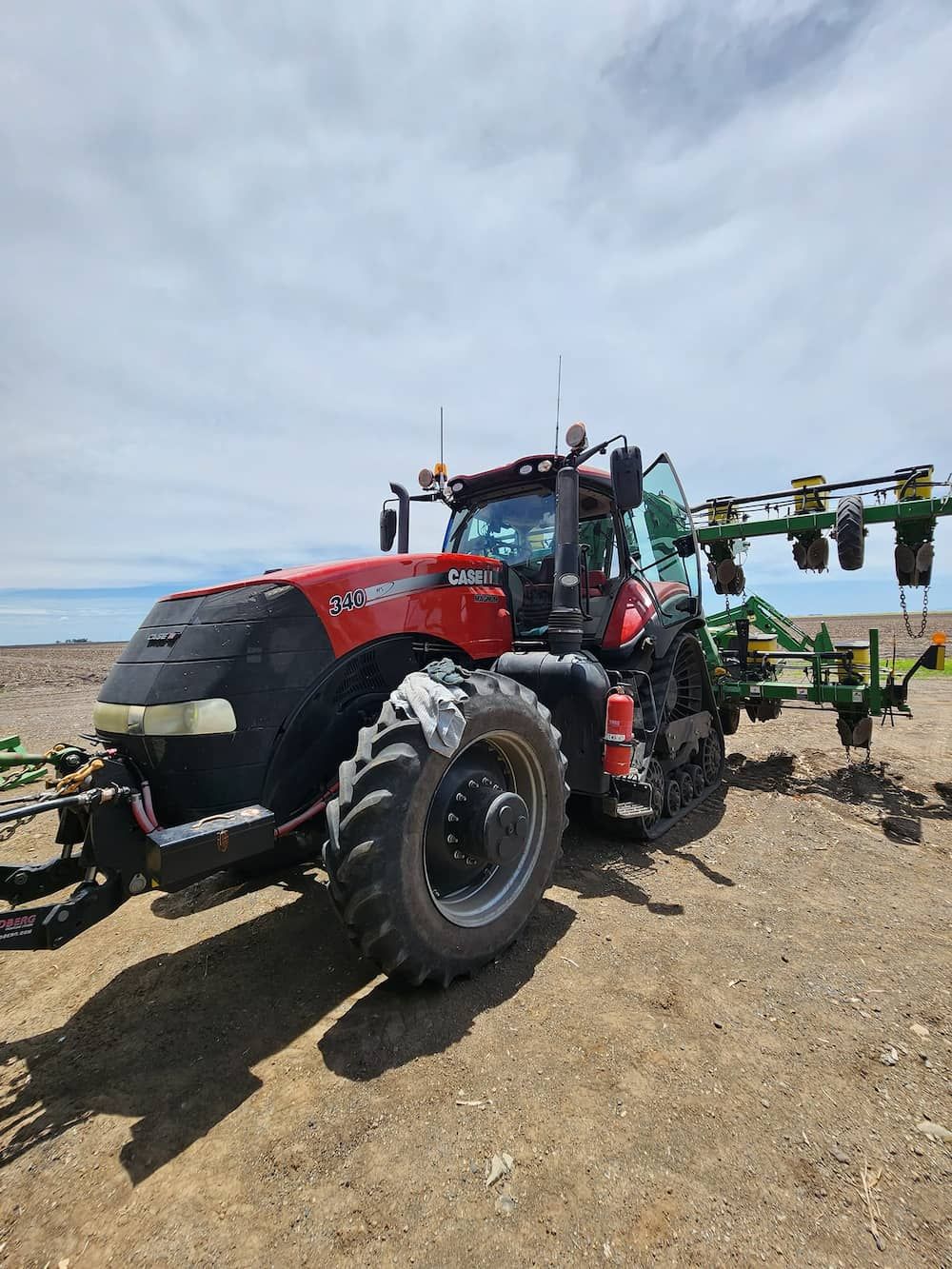 A Red And Black Tractor Is Parked In A Dirt Field — Petrena Windscreens In Toowoomba City, QLD