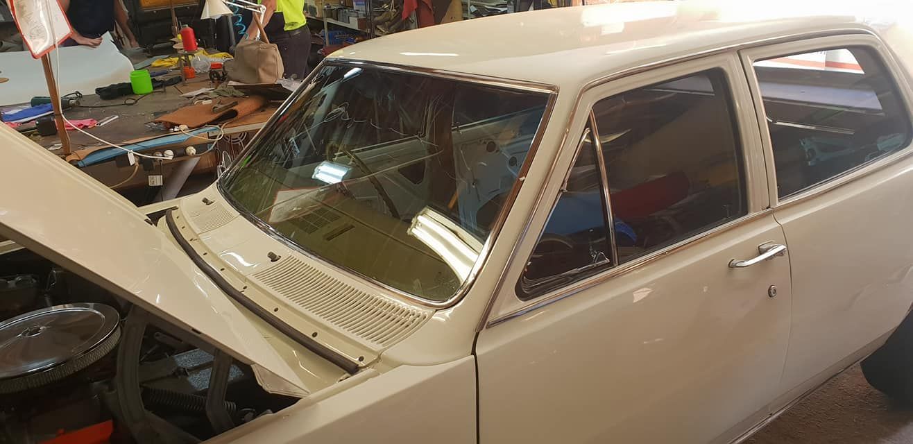 A White Car With The Hood Up Is Parked In A Garage — Petrena Windscreens In Millmerran, QLD