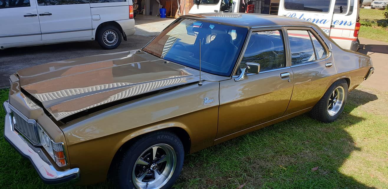 A Brown Car With The Hood Up Is Parked In The Grass Next To A White Van — Petrena Windscreens In Clifton, QLD