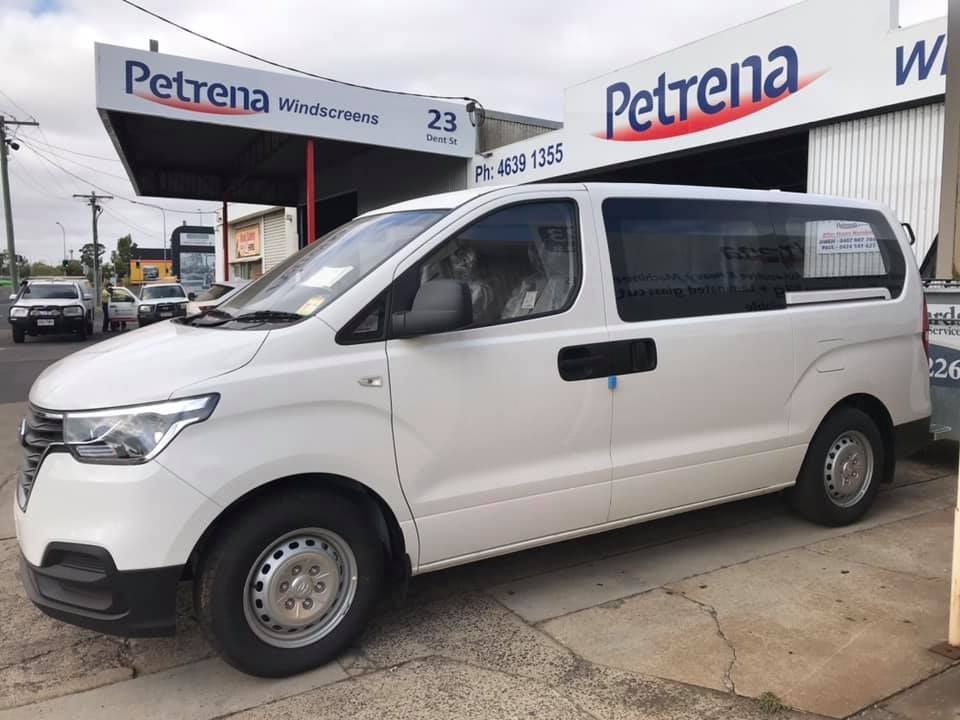 A white van is parked in front of a building that says petrena.  — Petrena Windscreens In Toowoomba City, QLD