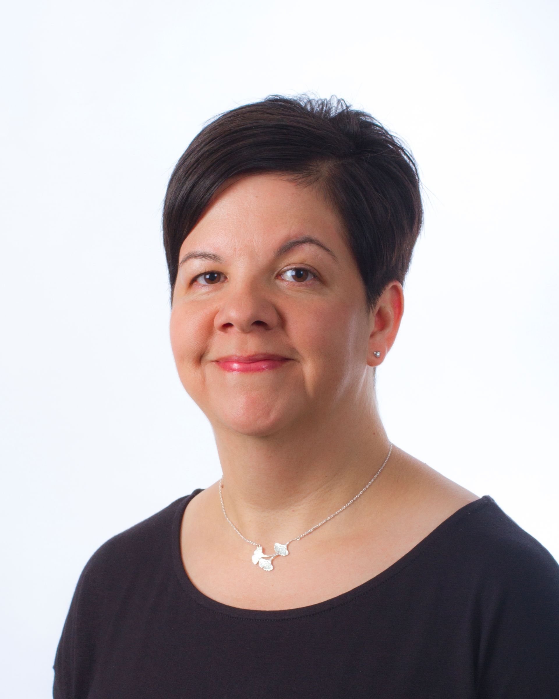 Woman smiles against a white backdrop.