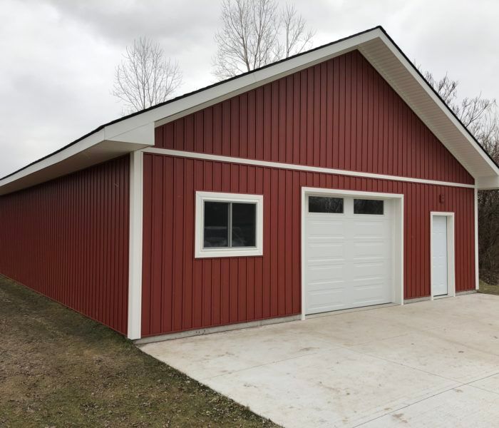 A red barn with a white garage door and windows