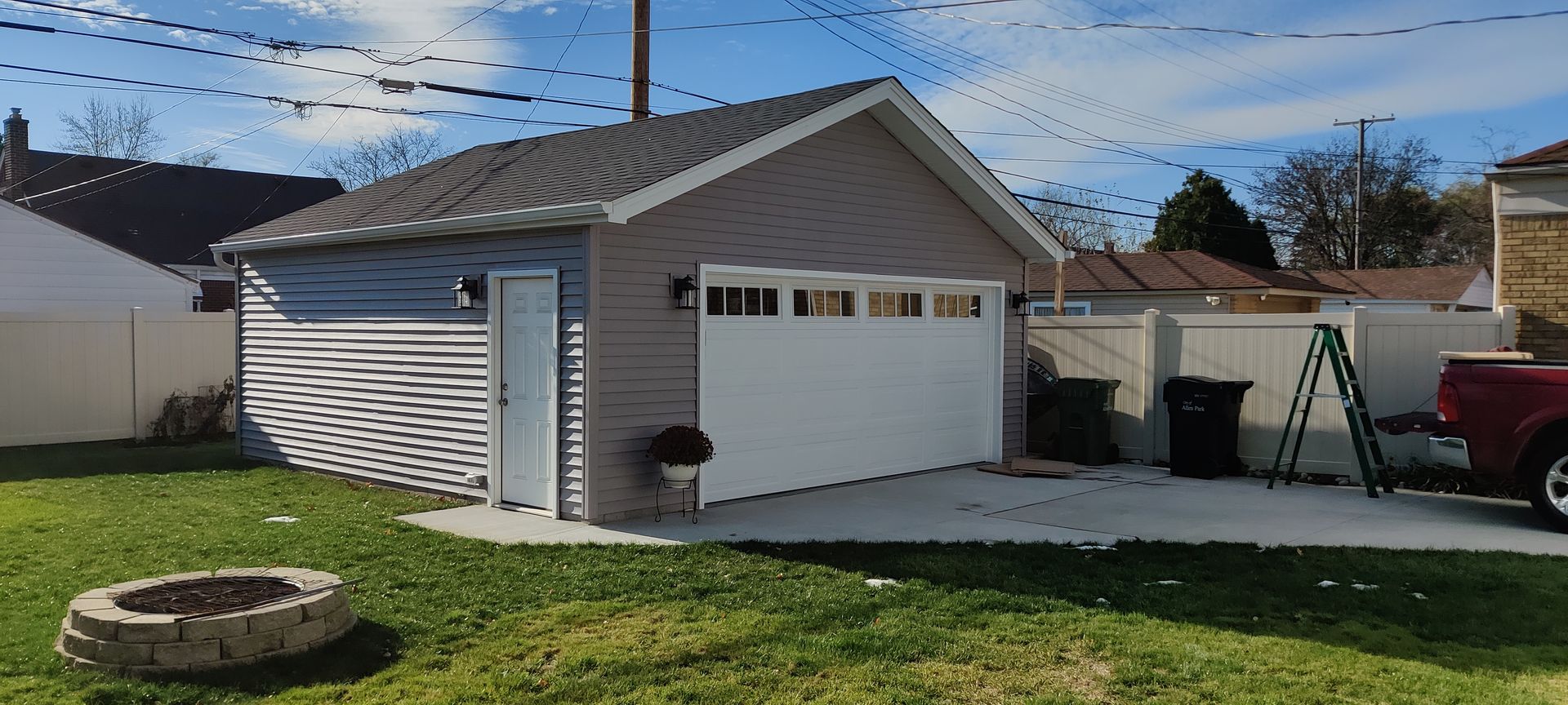 A red truck is parked in front of a garage.