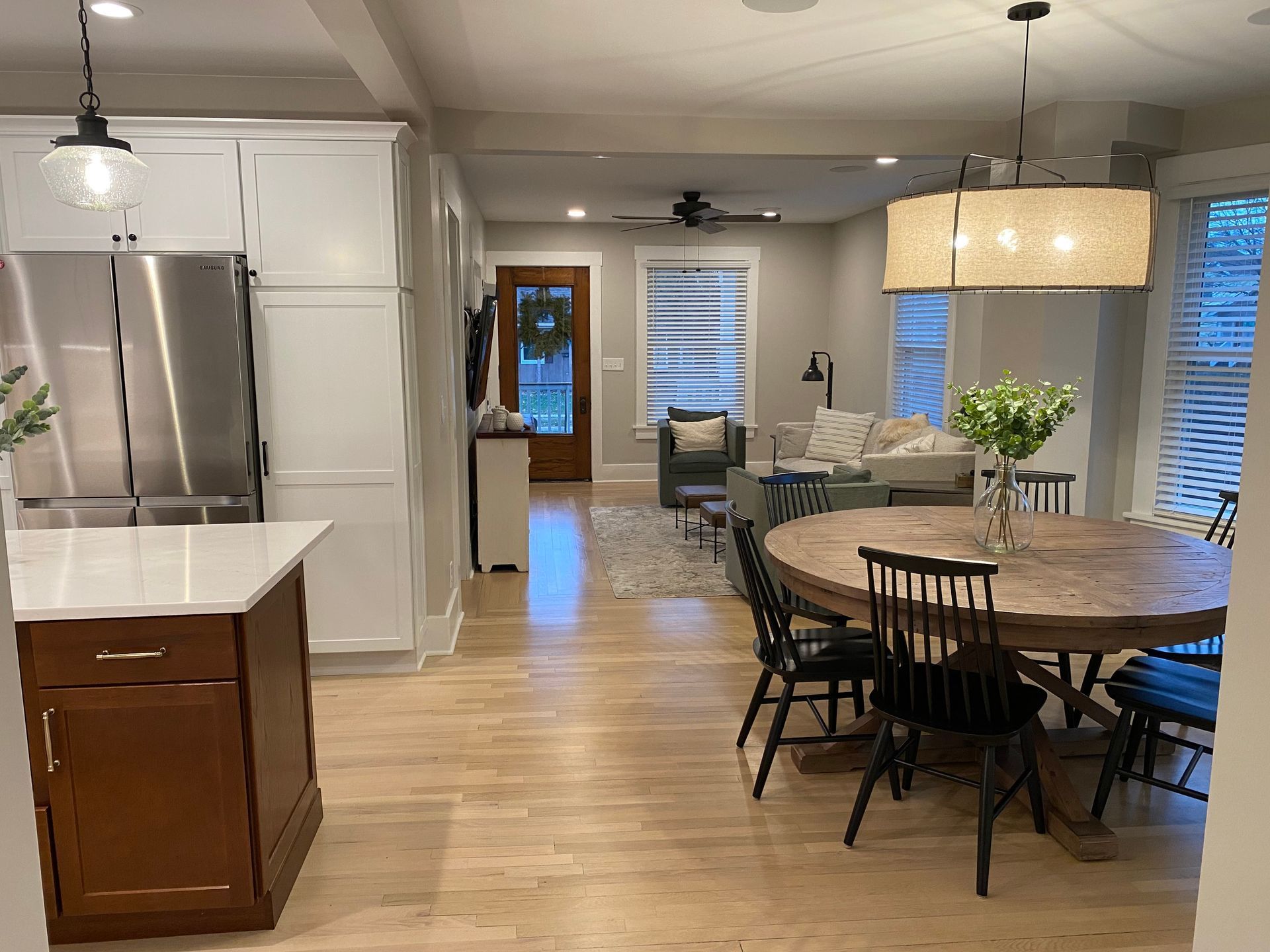 A kitchen with a table and chairs and a stainless steel refrigerator.