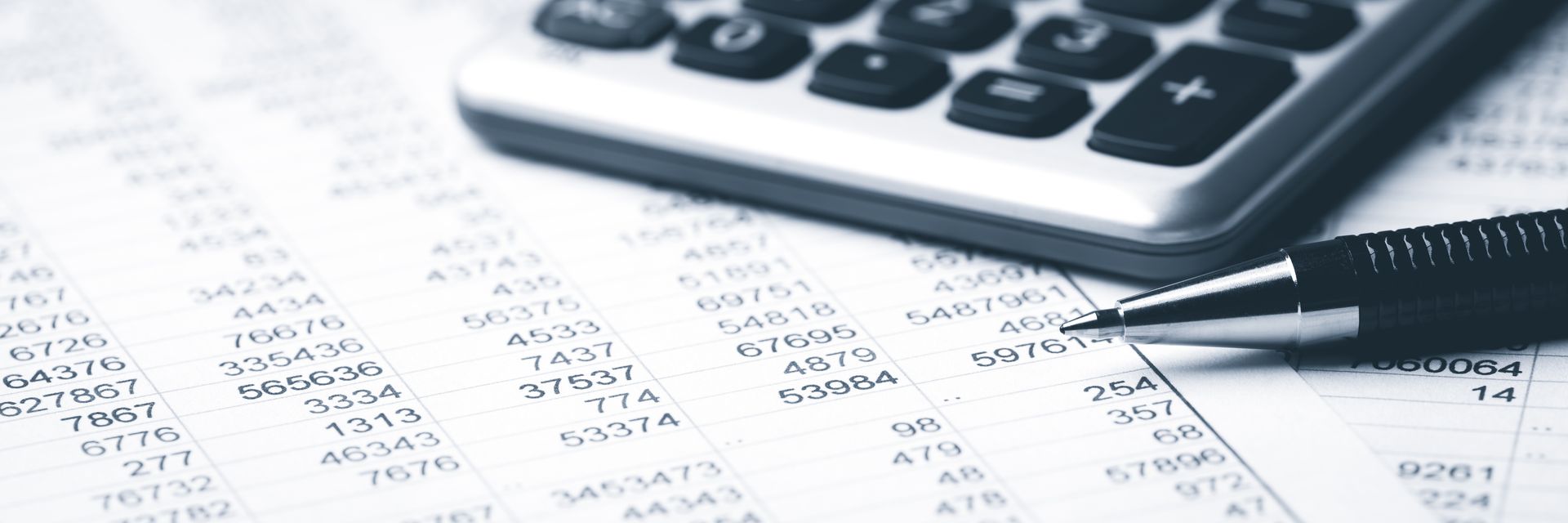 Calculator, pen, and financial documents on a desk, suggesting accounting or budgeting work