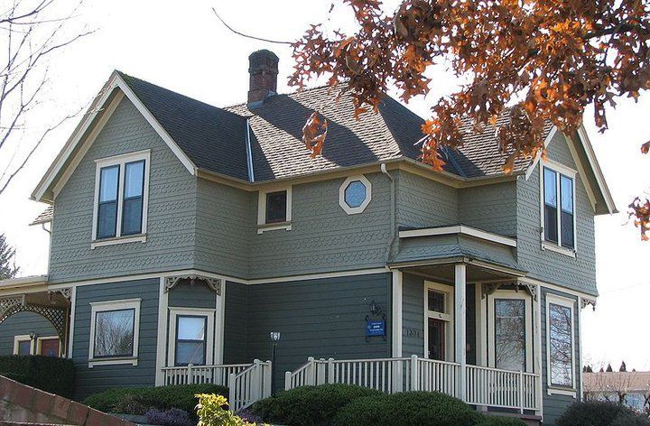 A large grey house with a black roof
