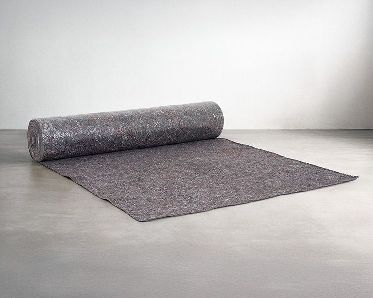 Een rol grijs viltmateriaal uitgerold op een betonnen ondergrond.