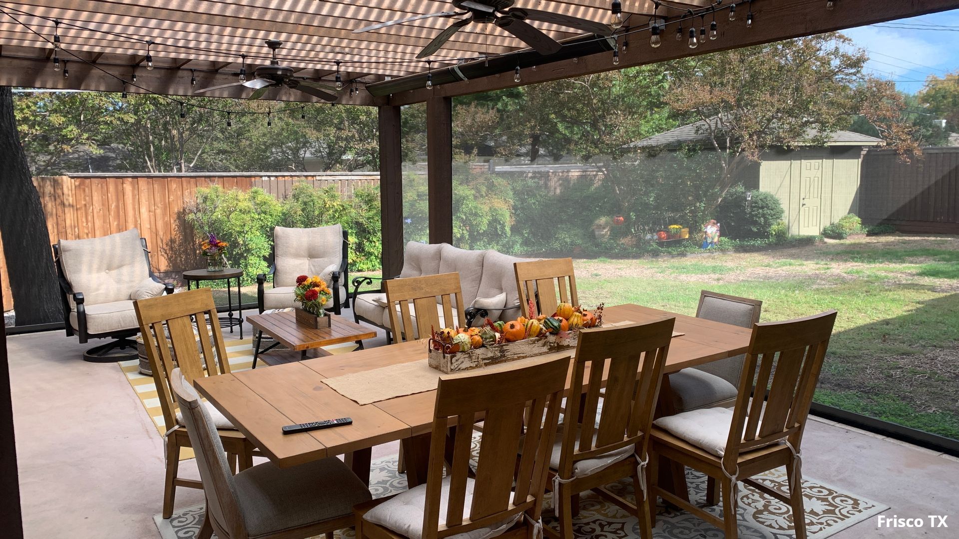 A motorized patio screen keeping the bugs at bay with a beatuiful outdoor dining table in Frisco TX