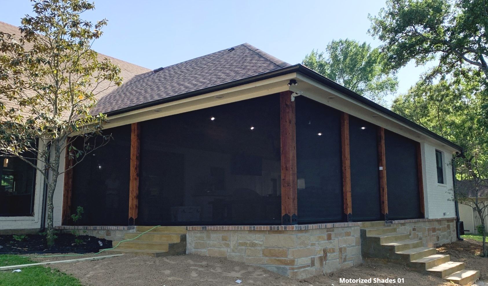 5 motorized patio shades with a stone foundation accent