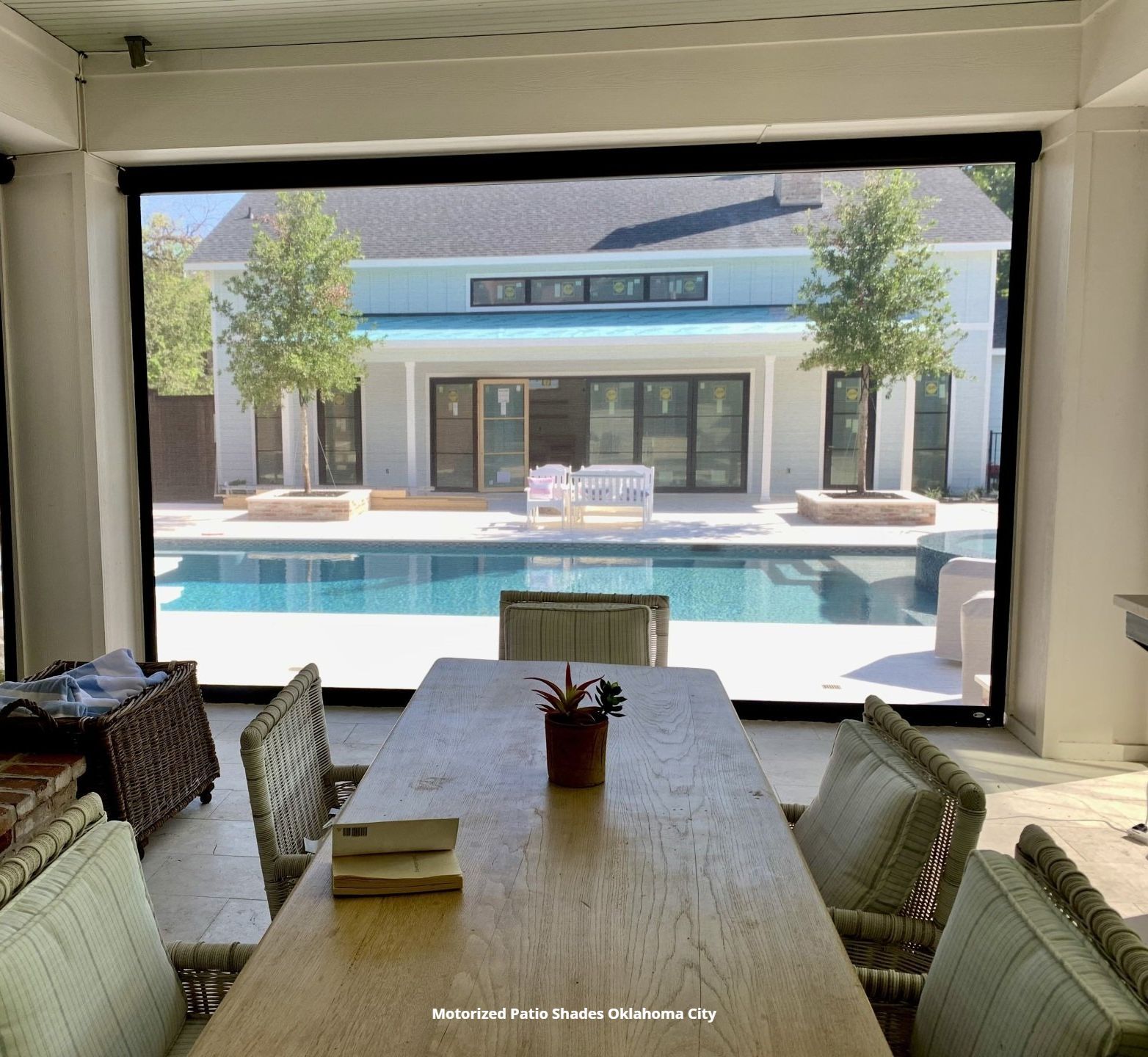 a patio with an outdoor dining table and chairs with a view through the motorized patio shade oklahom acity