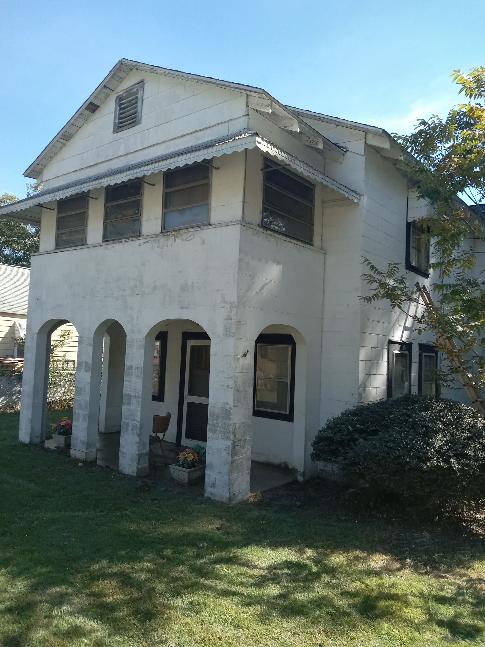A white house with arches and a blue sky in the background