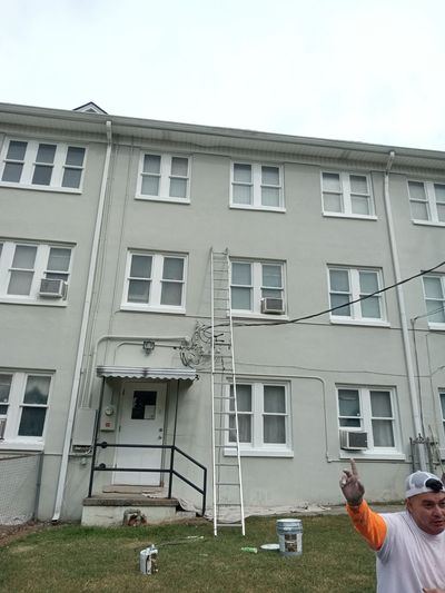 A man is painting the outside of a building
