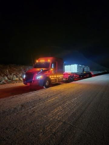 A red semi truck with the word genesis on the side