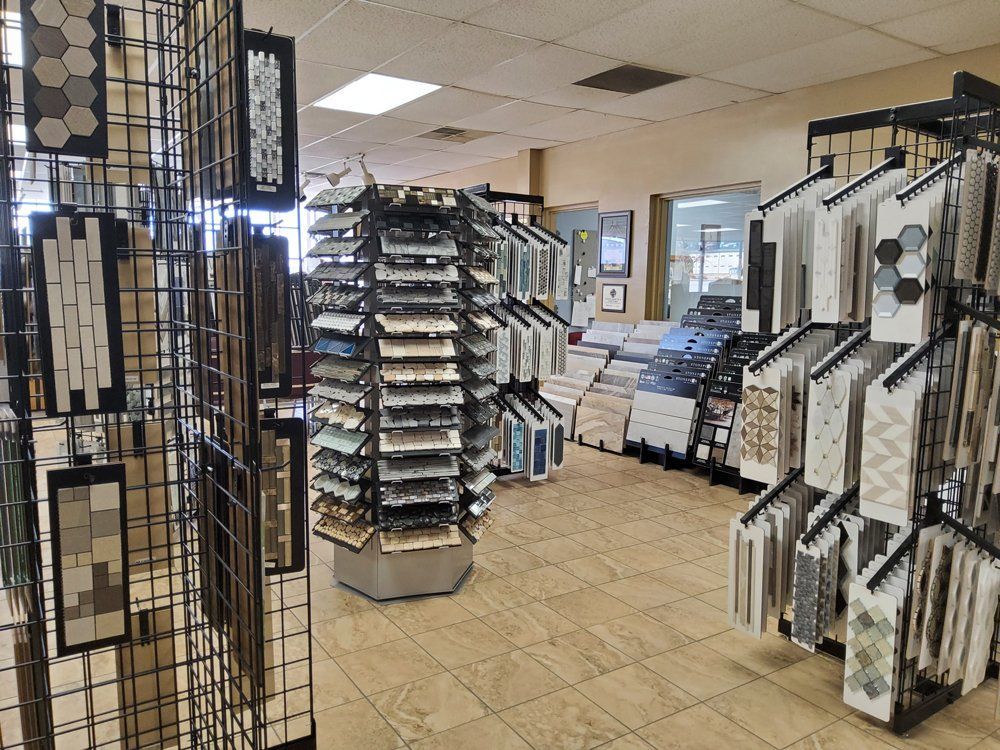 Display room with racks of picture frames and artwork samples on tiled floor and ceiling lights