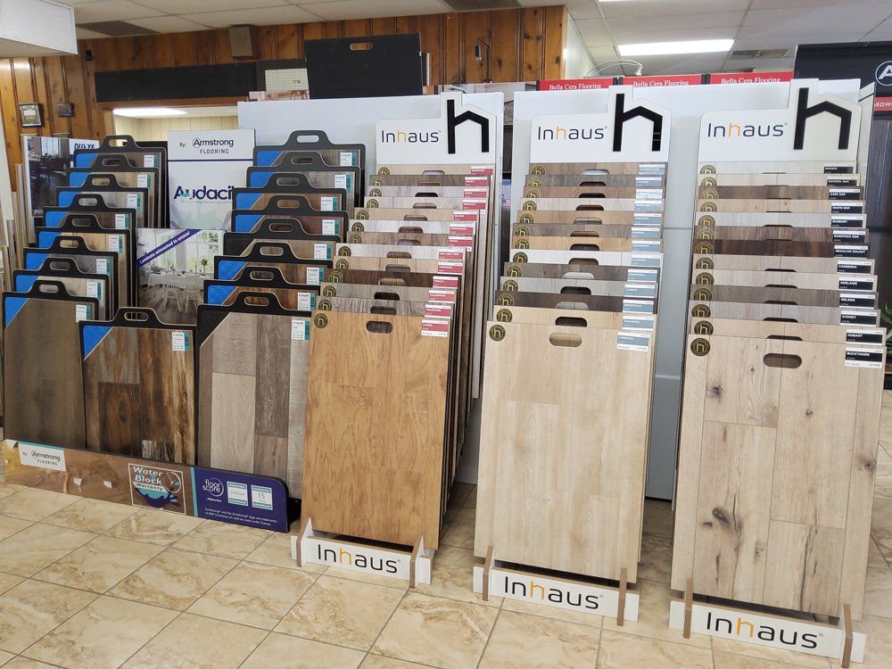 Flooring sample display in a showroom with rows of wood and tile planks