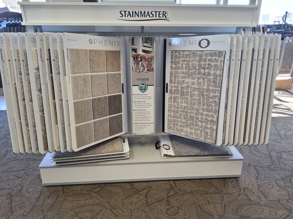 Stainmaster carpet display stand with multiple textured carpet samples in a store.