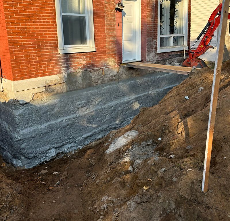 Un gros tas de terre se trouve devant un bâtiment en briques.