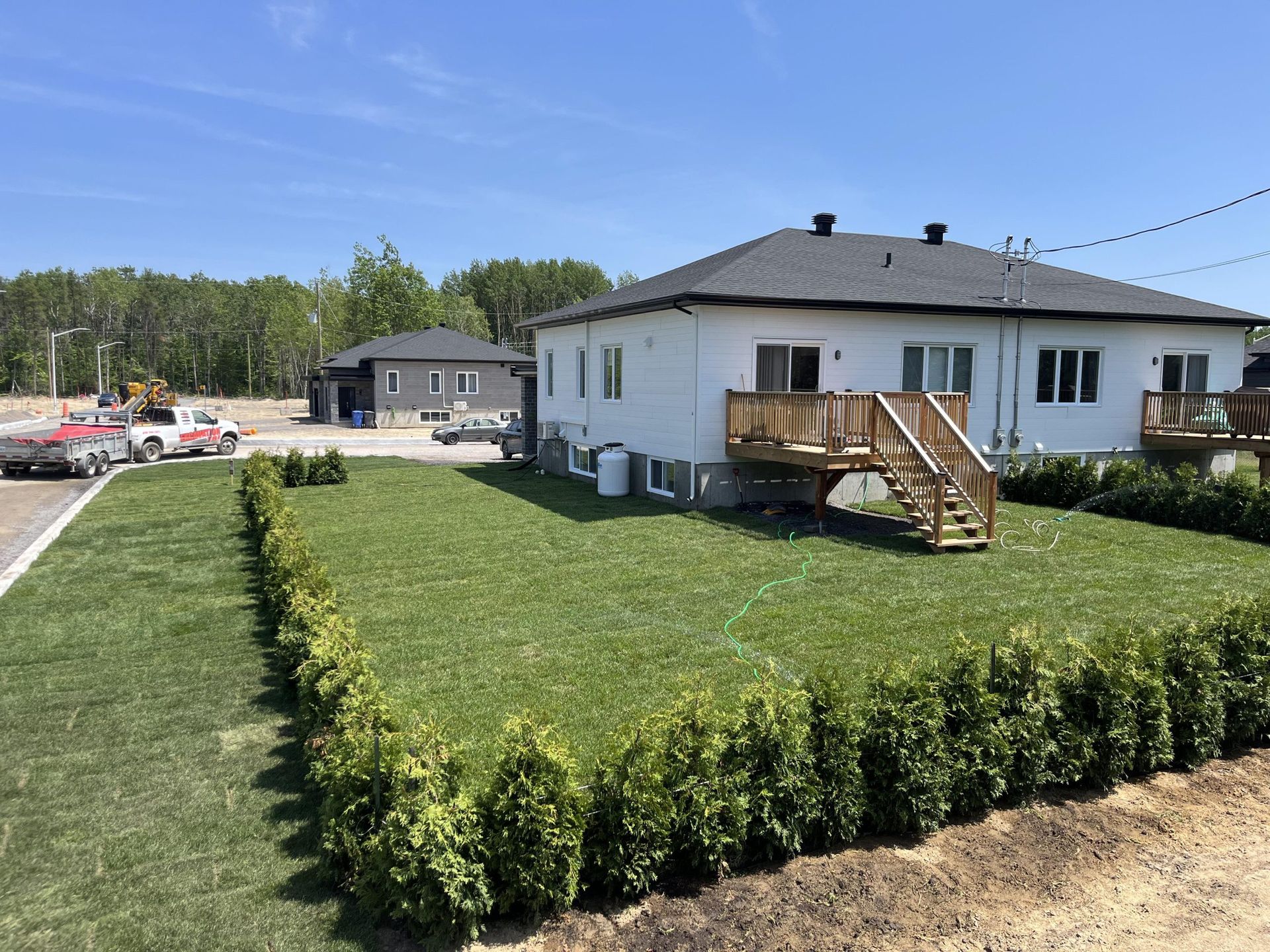 Une maison blanche avec une grande pelouse devant elle.