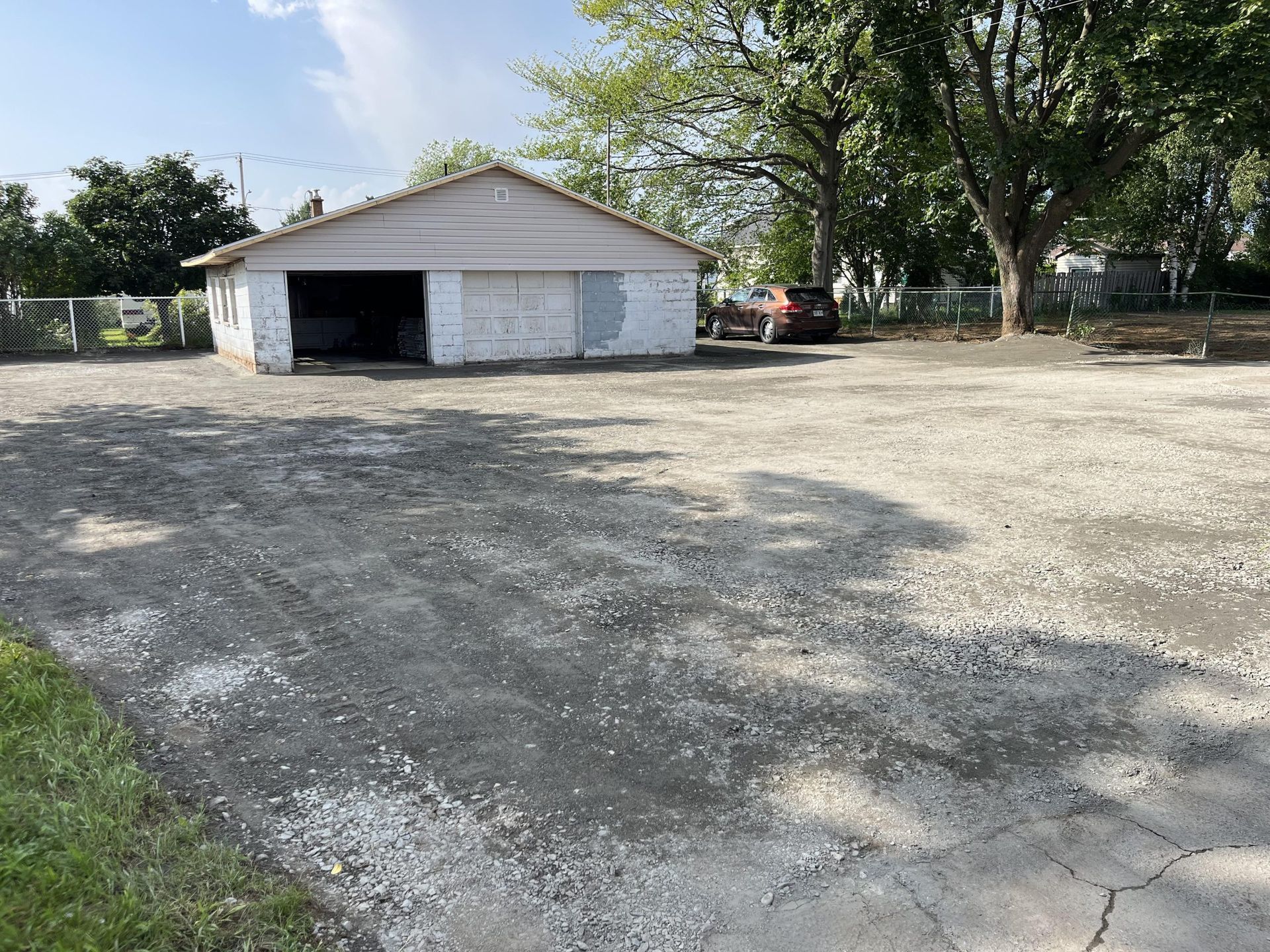Un garage blanc avec un camion rouge garé devant.