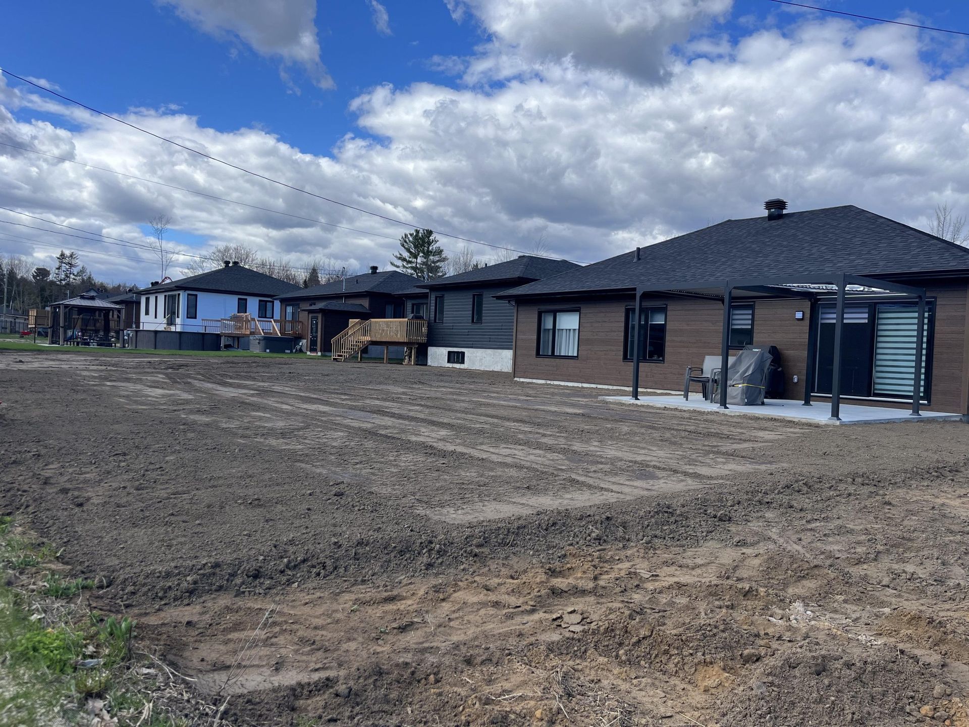 Une rangée de maisons est située au sommet d'un champ de terre.