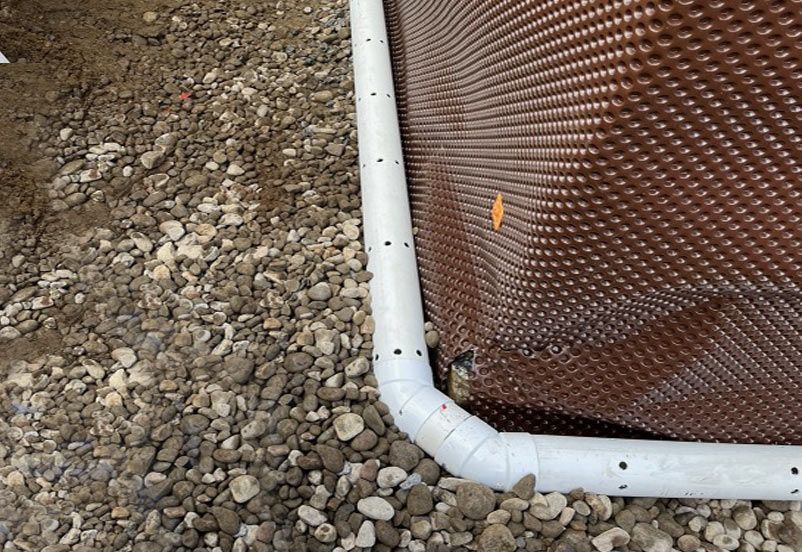 Un tuyau blanc est relié à un mur marron.