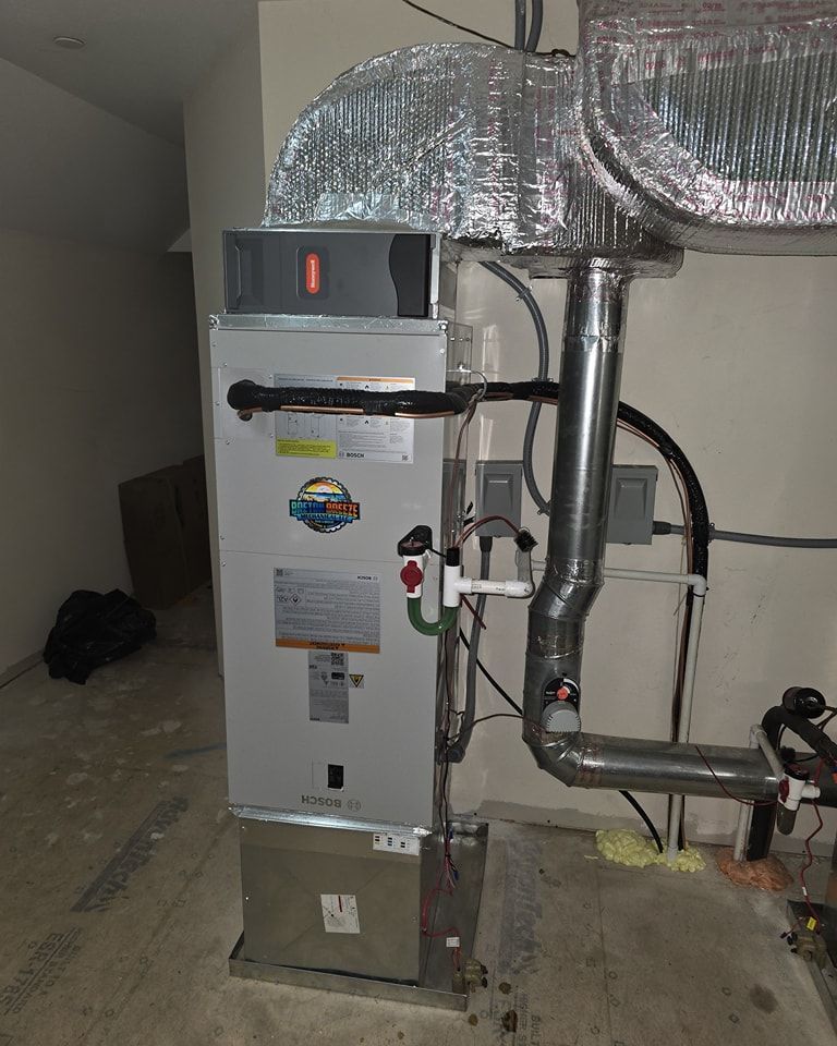 Furnace in a room with ductwork, piping, and electrical components.