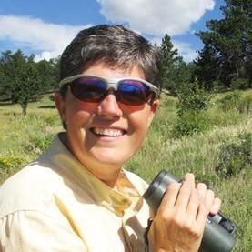 photo of Sue Riffe holding binoculars