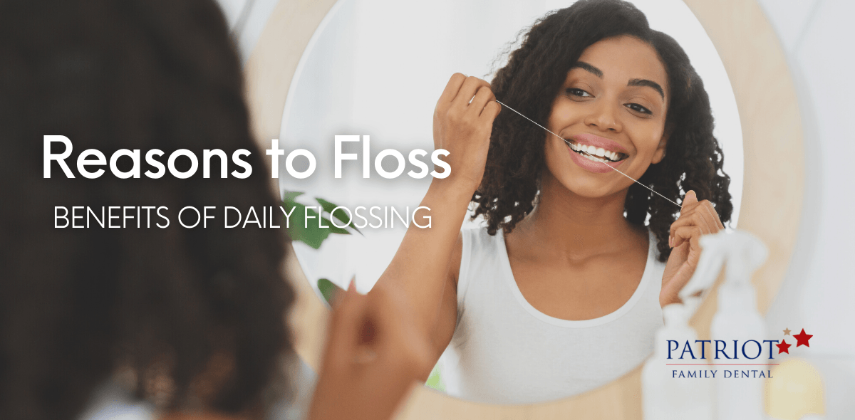 Black woman flossing by a mirror