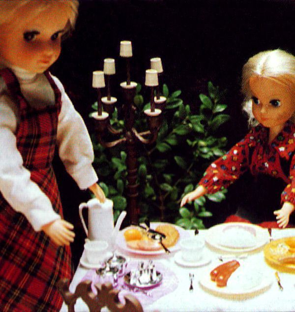 Fleur dolls having dinner and tea in living room with candleholder in the background