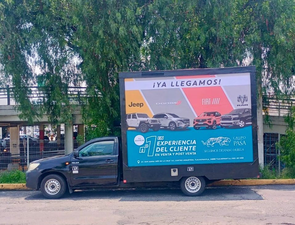 Camión negro con pantalla publicitaria digital; publicidad de Jeep, Fiat y otros vehículos.