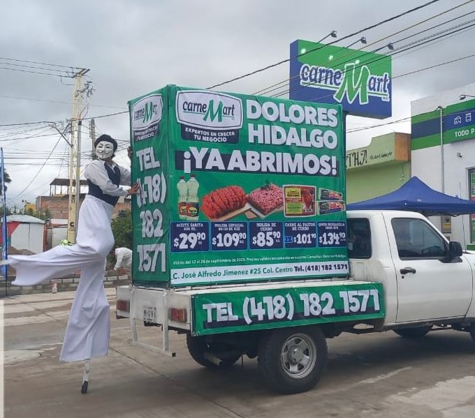 Un zanquero promociona Carne Mart en un camión en Dolores Hidalgo, con especiales de apertura.