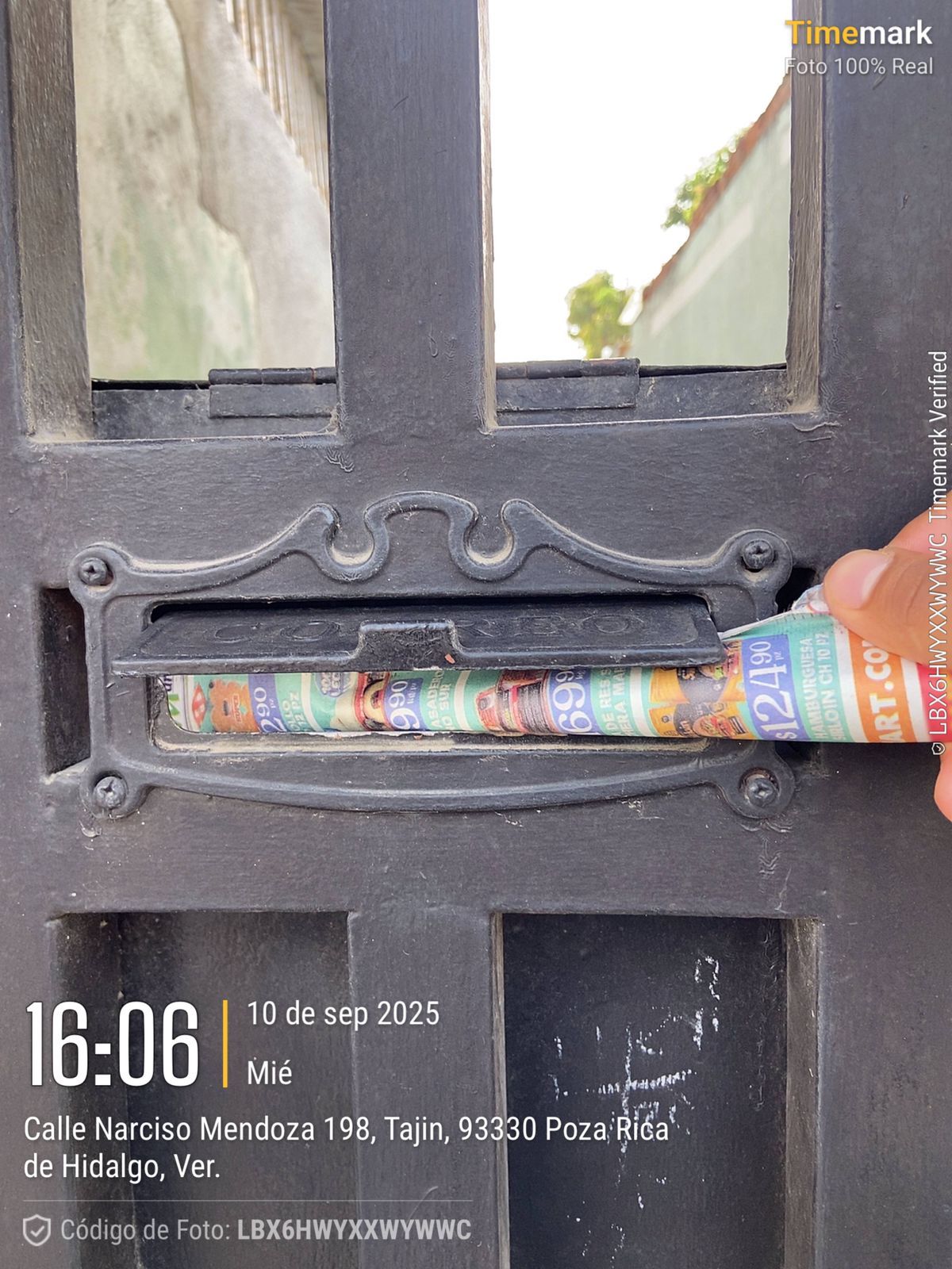 Persona insertando correo en un buzón de metal negro en una puerta a las 16:06 del 10 de septiembre de 2023. Detalles de la ubicación en la parte inferior.