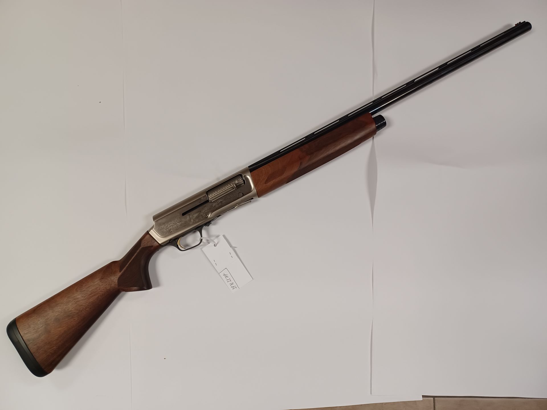 Fusil de chasse semi-automatique marron et argent avec crosse en bois et canon long, sur fond blanc.