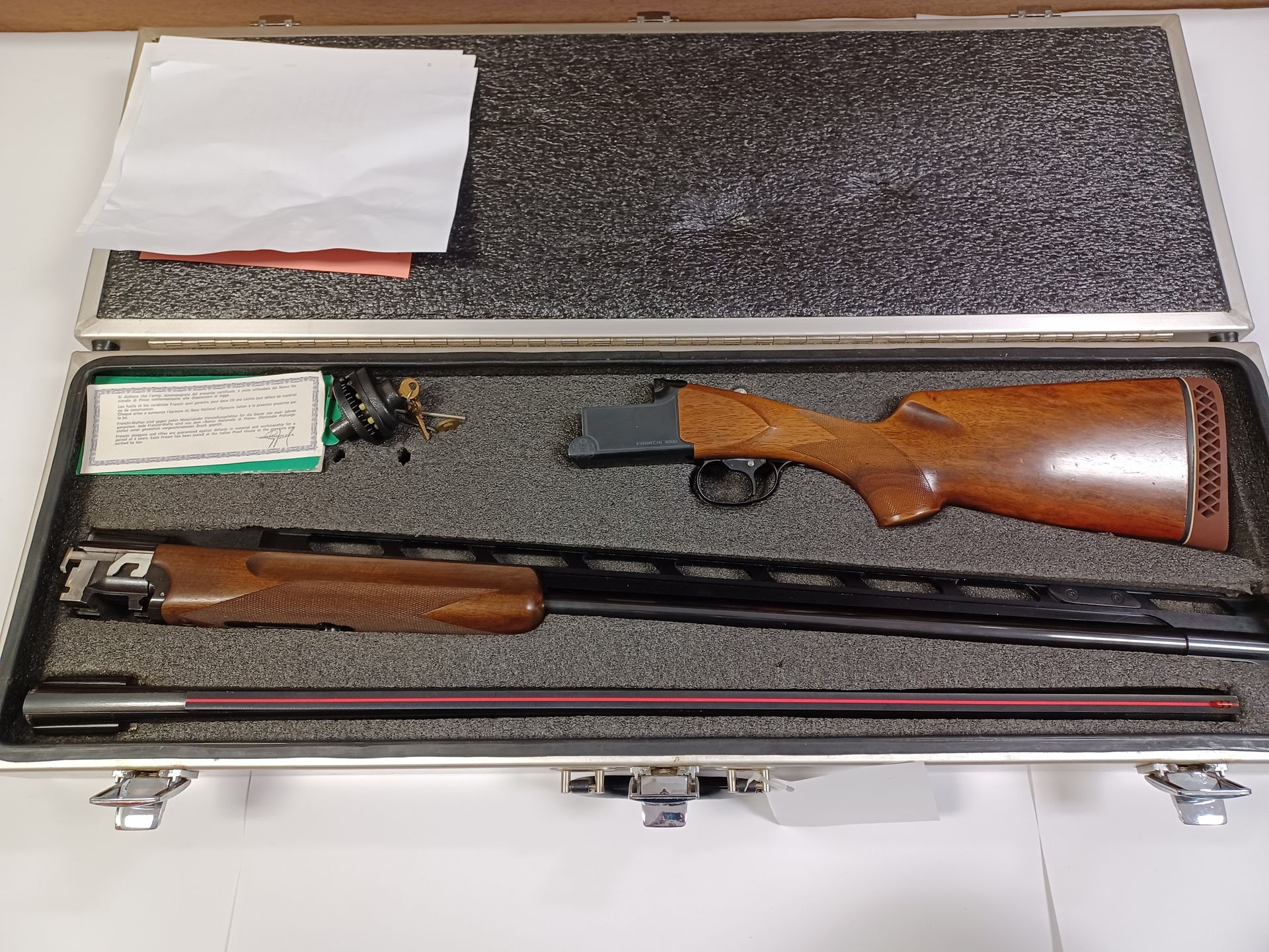 Fusil de chasse démonté, livré dans un étui avec crosse et canon en bois. Accessoires et documents présents.