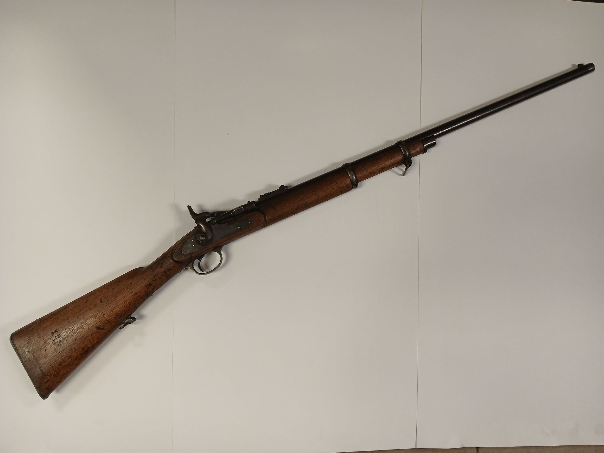 Long fusil en bois avec un canon en métal et une détente ornée.