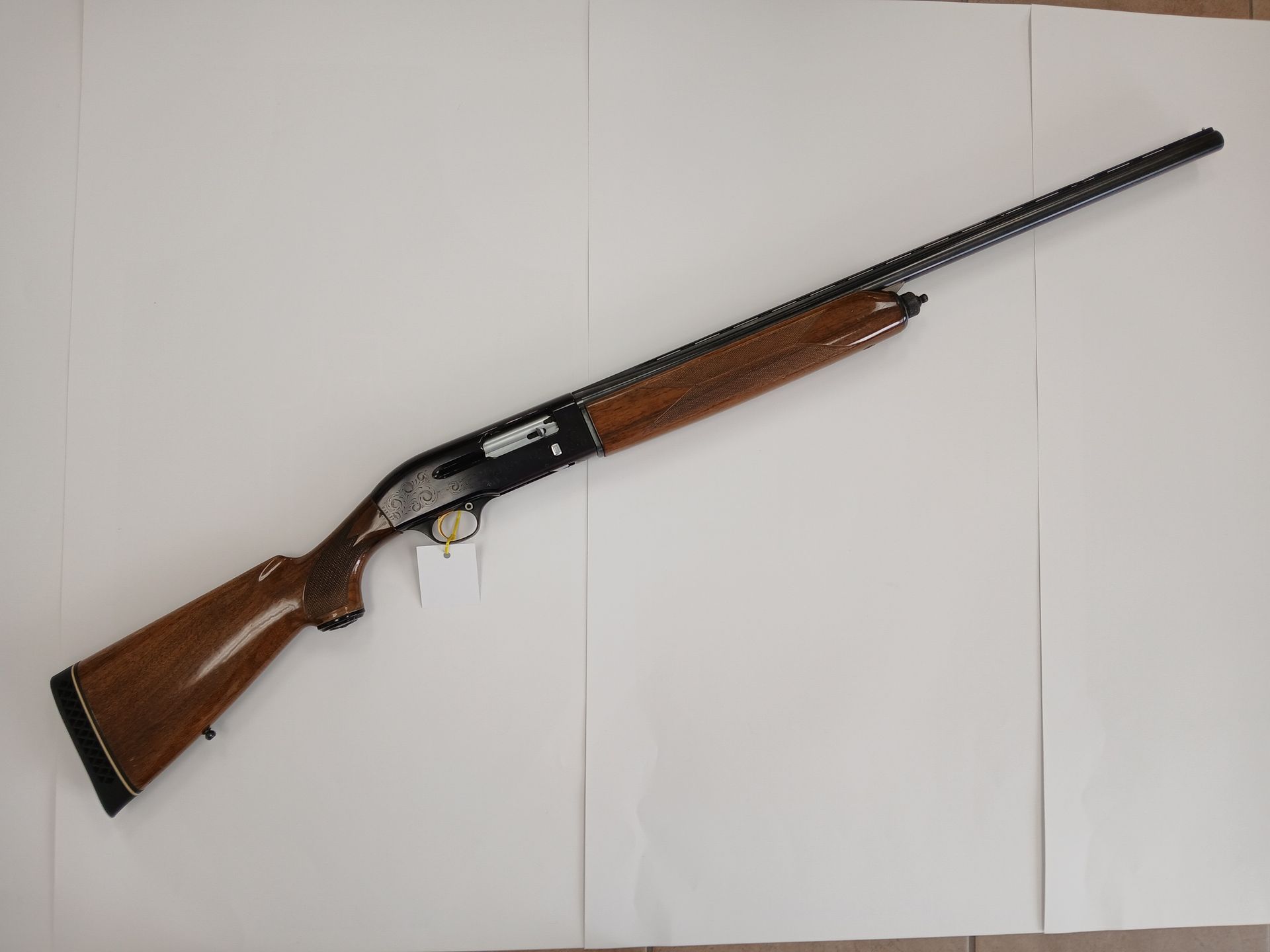 Fusil de chasse marron et noir sur fond blanc.