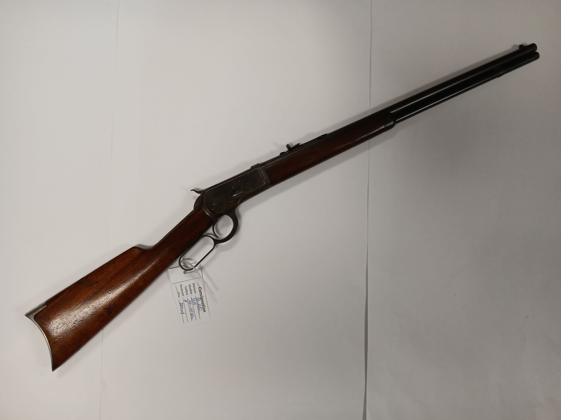 Carabine à levier, crosse et canon en bois brun, sur fond blanc uni.