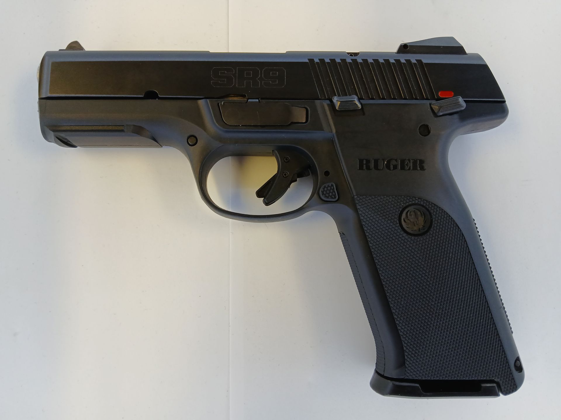 Black Ruger SR9 pistol, right side view, on a white background.