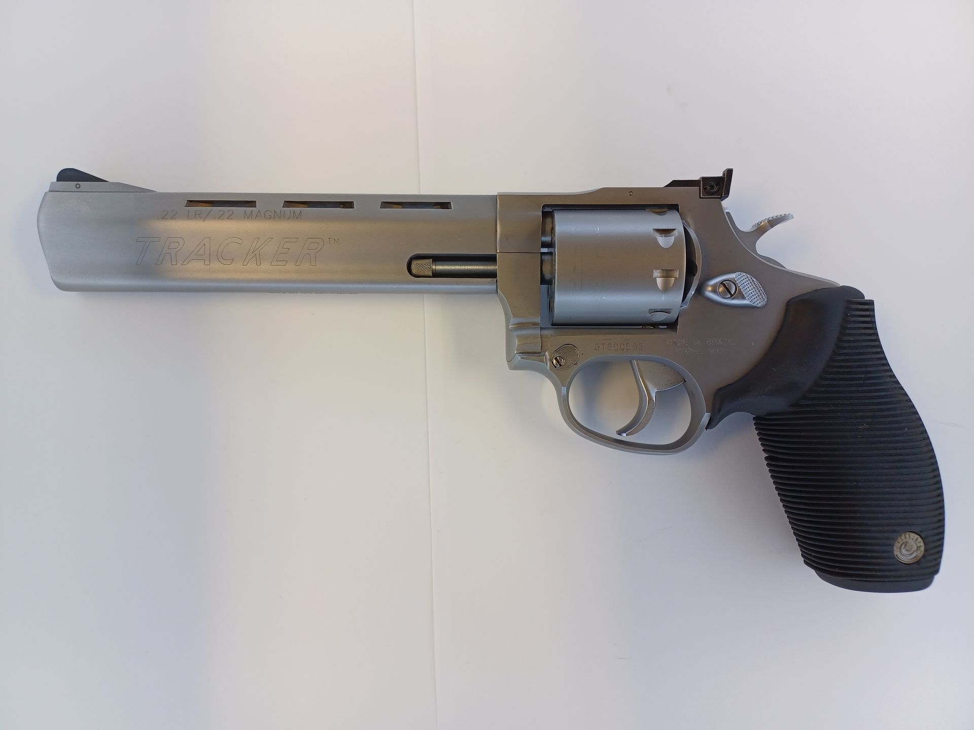 Silver revolver pistol with black grip on a white surface.