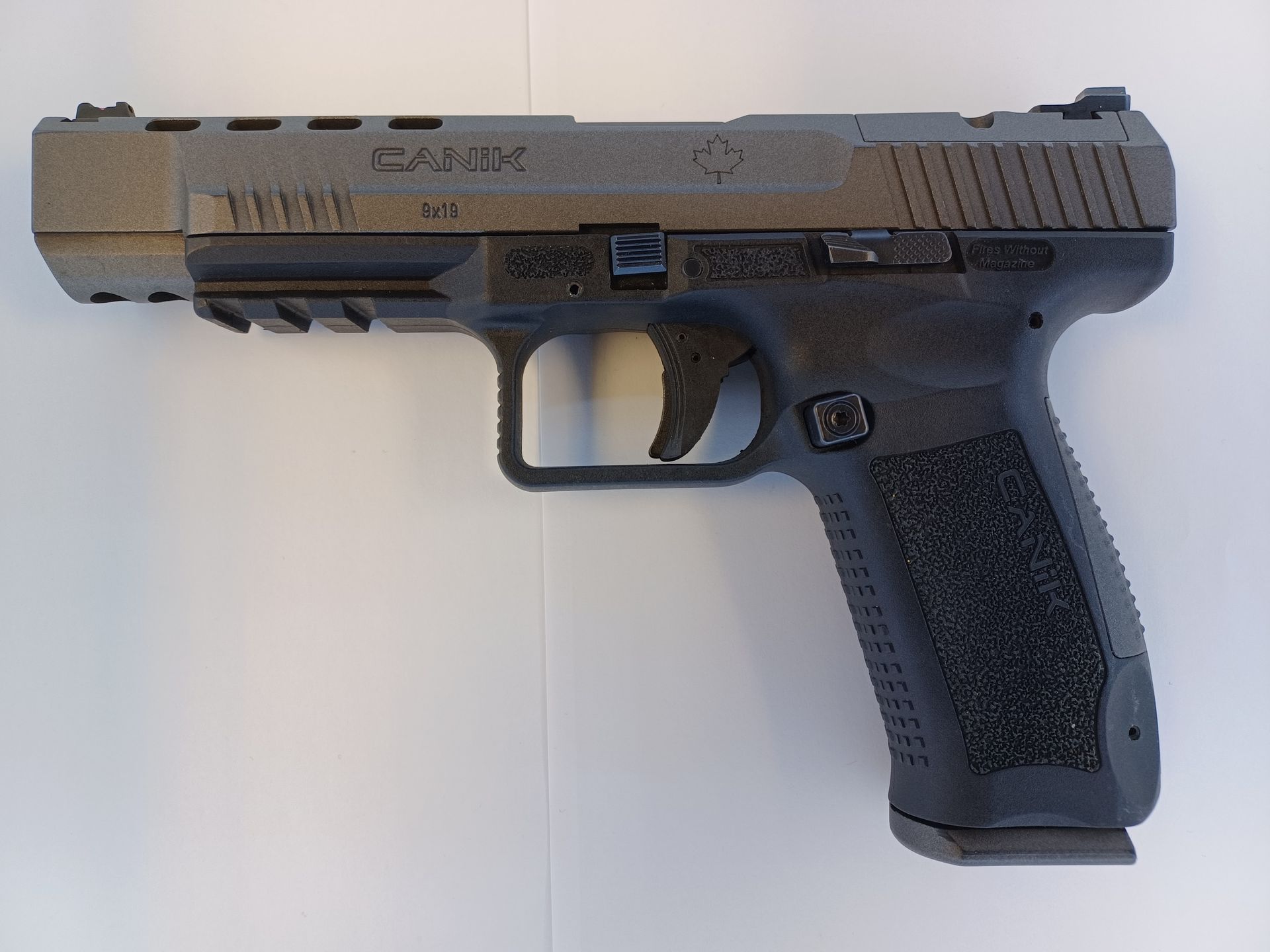 Dark gray and black handgun on a white surface.